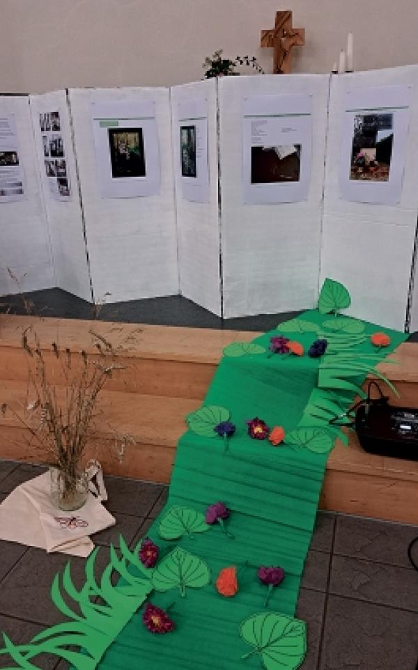  Zeleny slěd dopomina na citat z basni Miny Witkojc, &rsaquo;Do maja&lsaquo; (1955), kenž m&oacute;žomy cytaś na jeje rowowem pomniku:  &raquo;Daś za nami ceri se w&scaron;uder / jan zeleny, kwiśecy slěd. / Und nach uns geh, wo wir gegangen / eine maigr&uuml;ne Bl&uuml;tenspur.&laquo;, pśestajony w&oacute;t Kita Lorenca 1976. Na zachopjeńku su sobustatkujuce na njom w&oacute;tpołožyli z ruku źěłane papjerjane kwětki, citěrujucy pśi tom baseń Miny Witkojc &rsaquo;Kwětki&lsaquo; (1926) &ndash; nimski &rsaquo;Blumen&lsaquo; w pśe-stajenju Elke Nagel, 2001.  Foto: Christiana Piniekowa